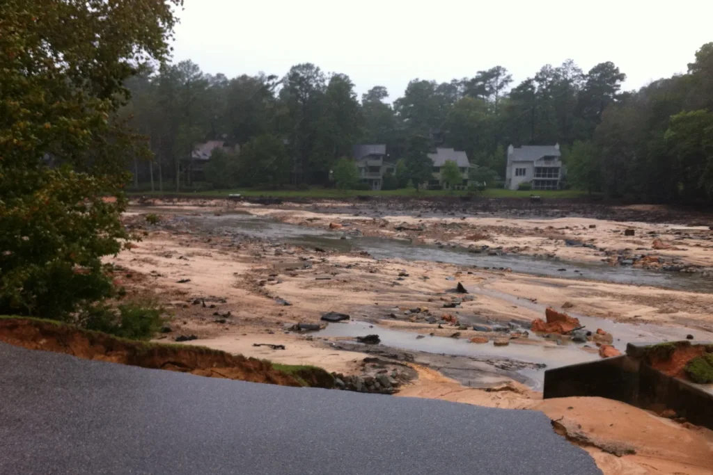 A washed-out road edge above a drained, debris-strewn lakebed after the October 2015 flooding in South Carolina.